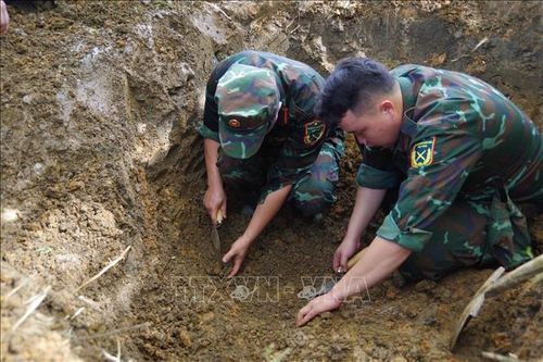 Lực lượng chức năng tổ chức cất bốc, quy tập hài cốt liệt sĩ Mã Văn Gì tại xã Minh Tâm. Ảnh: Phương Quyền/TTXVN phát