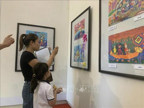 Các em nhỏ và phụ huynh tham quan triển lãm tranh.