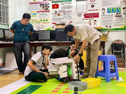 Giáo viên hướng dẫn học sinh hoàn thiện robot trong buổi sinh hoạt Câu lạc bộ Robocon Trường THCS Trưng Vương. Ảnh: Minh Chí