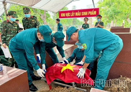 Lực lượng dân quân tự vệ hỗ trợ quá trình lấy mẫu hài cốt liệt sĩ.