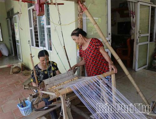 Bà Hà Thị Dây (bên phải) và cháu gái Sa Thị Đoàn vẫn gắn bó với khung cửi.