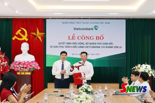 Ông Hồng Quang, Thành viên HĐQT, Kiêm Giám đốc khối nhân sự Vietcombank trao quyết định và hoa chúc mừng ông Đậu Nam Long