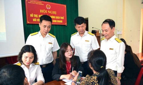 Công chức Thuế tỉnh Ninh Bình hỗ trợ, hướng dẫn chính sách thuế cho hộ kinh doanh. Ảnh: Trường Giang