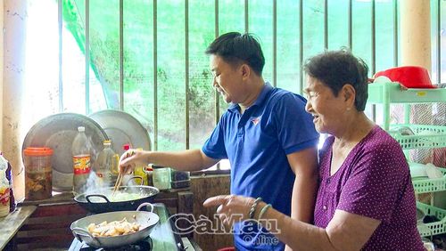  Anh Nguyễn Văn Đề, Bí thư Xã đoàn Ninh Thạnh Lợi, cùng cựu chiến binh Lê Thị Sấm chuẩn bị bữa cơm sum vầy.