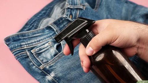 Pha giấm và nước ấm xịt lên chỗ bẩn trên quần jeans. (Ảnh: Wikihow)