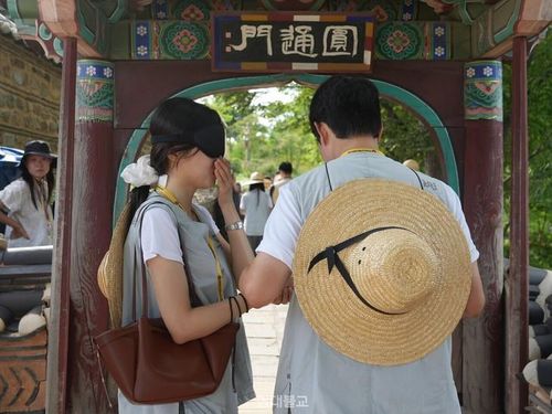 Hoạt động đi bộ bịt mắt dọc theo con đường cầu nguyện tới tượng Quán Thế Âm Bồ Tát là điểm nhấn độc đáo của khóa tu "mai mối" tại chùa Naksansa. Ảnh: Huynbul News