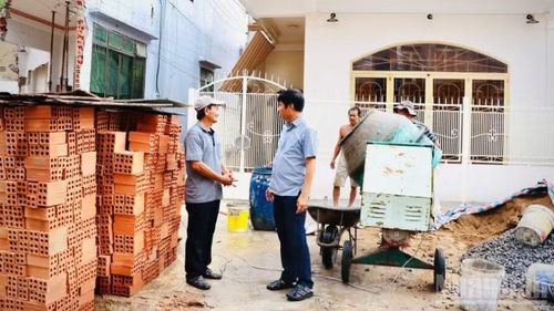 Ông Nguyễn Ngọc Tú (bên trái) hoàn thiện phần trước ngôi nhà sau khi tháo dỡ, bàn giao diện tích trước nhà để thực hiện Dự án đường đấu nối khu tái định cư 6,2ha với đường Trần Quốc Toản.
