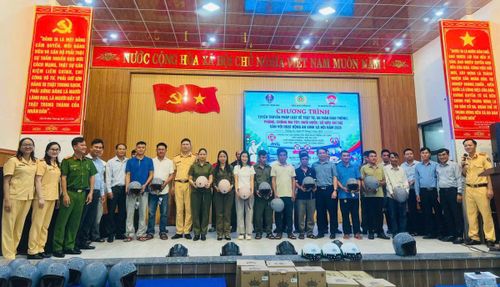 Người dân nhận mũ bảo hiểm đạt chuẩn trong chương trình tuyên truyền an toàn giao thông. (Ảnh CA)