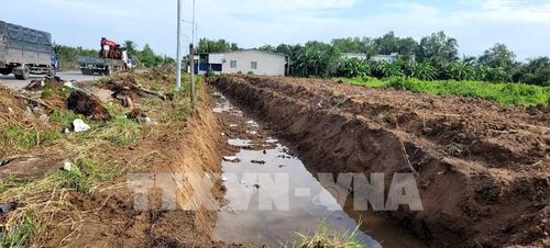Việc đào lấy đất làm ảnh hưởng trực tiếp đến tiến độ thi công Dự án nâng cấp, mở rộng Đường tỉnh 878. Ảnh: Công Trí - TTXVN