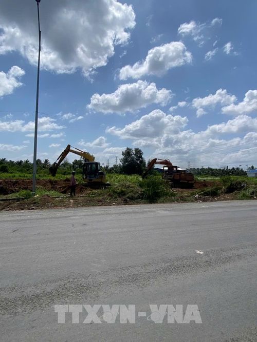 Người dân tự ý đào lấy đất trong phạm vi mặt bằng đường tỉnh 878 đang thi công (đoạn qua xã Long Hưng). Ảnh: Công Trí - TTXVN 