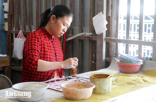 Thợ đang sơn màu cho tranh kiếng.