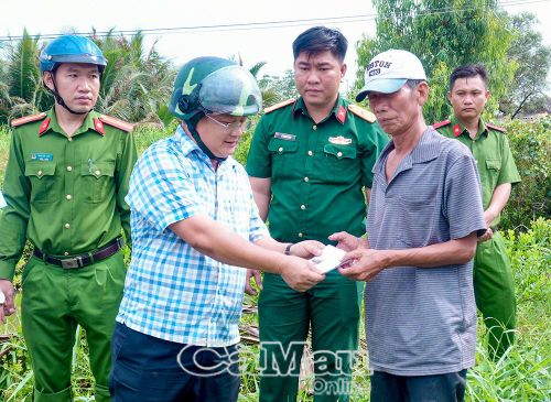 Ông Phan Thanh Liêm, Bí thứ Đảng ủy, Chủ tịch HĐND xã Tân Hưng trao tiền hỗ trợ đông viên hộ dân bị thiên tai vượt qua khó khăn ổn định cuộc sống.