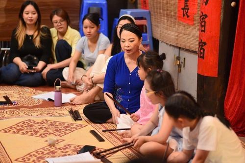 Các bạn trẻ chăm chú nghe Nghệ nhân hát ca trù tại lớp học ca trù tại Di tích lịch sử - văn hóa Bích Câu Đạo Quán (Hà Nội). Ảnh: Tuyết Mai - TTXVN