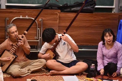 Nghệ nhân Ưu tú Trần Koóng dạy học viên mới cách đánh đàn đáy. Ảnh: Hà Linh/TTXVN phát