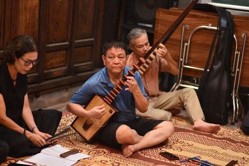 Nghệ nhân Ưu tú Trần Văn Chúc và Trần Koóng tập trung biểu diễn đàn đáy. Ảnh: Tuyết Mai - TTXVN
