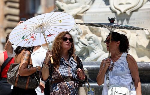 Khách du lịch che ô tránh nắng nóng tại Rome, Italy, ngày 10/7/2026