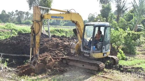 Người dân dùng máy xúc lấy đất trong dự án để san lấp phần đất của gia đình.