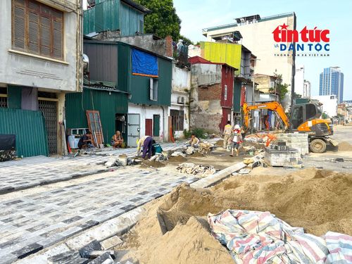 Các tốp công nhân đang thi công hạng mục vỉa hè trên đường Vành đai 1 đoạn từ nút giao Voi Phục đến Bệnh viện Phụ sản Hà Nội.