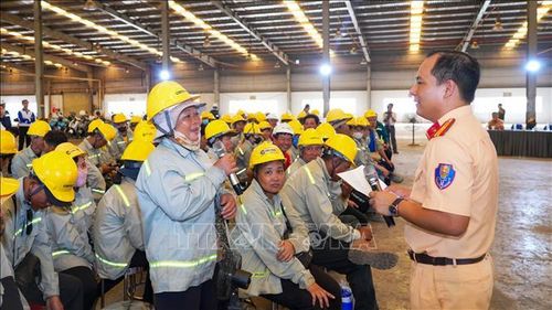 Cán bộ Cảnh sát giao thông Công an tỉnh Tây Ninh phổ biến các quy định của pháp luật về trật tự, an toàn giao thông cho công nhân, người lao động tại chương trình. Ảnh: Minh Phú - TTXVN
