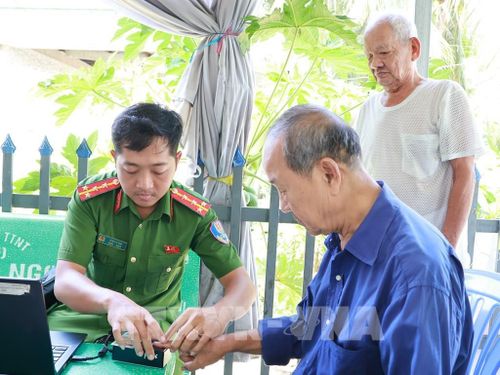 Lực lượng công an đến tận nhà thu thập thông tin để lấy mẫu ADN đối với người lớn tuổi đi lại khó khăn. Ảnh: Nhựt An - TTXVN