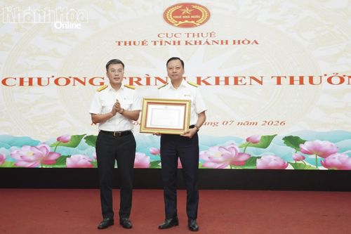 Đồng chí Lê Long trao bằng khen của Bộ Tài chính cho ông Nguyễn Ngọc Tú.
