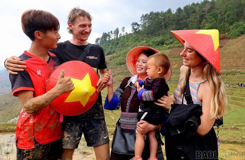 Khoảnh khắc giao lưu đầy thân thiện giữa người dân địa phương và du khách quốc tế trên những thửa ruộng bậc thang vùng cao Mù Cang Chải. Những chiếc nón mang hình lá cờ Tổ quốc cùng nụ cười rạng rỡ đã xóa nhòa khoảng cách ngôn ngữ, kết nối con người bằng sự chân thành và hiếu khách. Bức ảnh thể hiện sự giao thoa văn hóa, lan tỏa bản sắc dân tộc và sức hấp dẫn của du lịch cộng đồng vùng cao Tây Bắc.