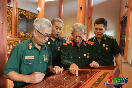 Các cựu chiến binh xem sổ vàng ghi danh các Anh hùng liệt sĩ tại Khu tưởng niệm tâm linh thuộc Di tích lịch sử Ngã ba Cò Nòi.
