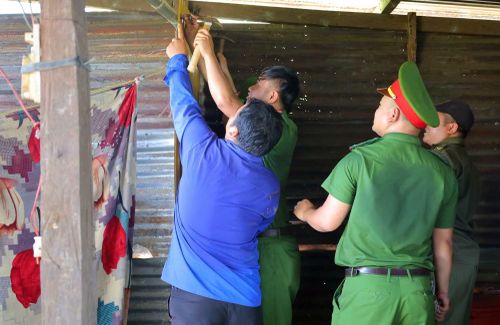 Cán bộ Công an xã Phước Năng tham gia hỗ trợ sửa chữa nhà cho người dân có hoàn cảnh khó khăn.