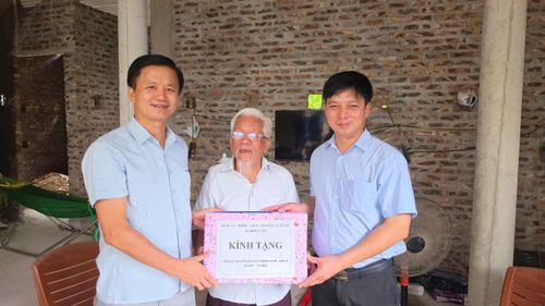 Phó Bí thư Thường trực Đảng ủy xã Hồng Vân Nguyễn Tuấn Đạt trao quà cho gia đình người có công. Ảnh: Vũ Hậu.