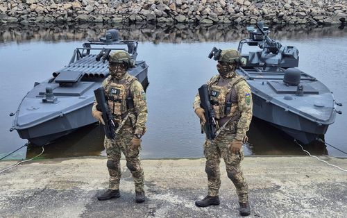  Các quân nhân thuộc Cơ quan An ninh Ukraine (SBU) bên cạnh phiên bản mới nhất của xuồng không người lái hải quân "Sea Baby", tại một địa điểm không được tiết lộ ở Ukraine, ngày 17/10/2025. Ảnh: Reuters. 