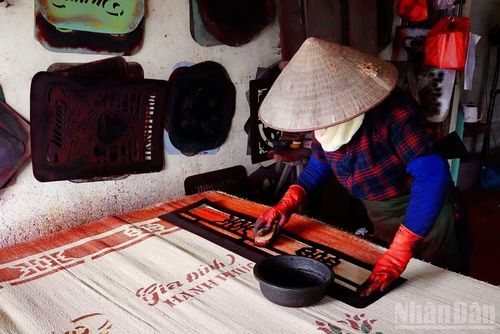 Người thợ in màu đang hoàn thiện nốt những công đoạn cuối cùng. (Ảnh: Hà Thương)