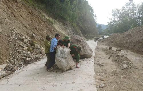 Công an xã Ngọc Chiến tham gia thu dọn đất, đá sạt lở tuyến đường lên bản Nậm Nghẹp do ảnh hưởng của hoàn lưu bão số 1.