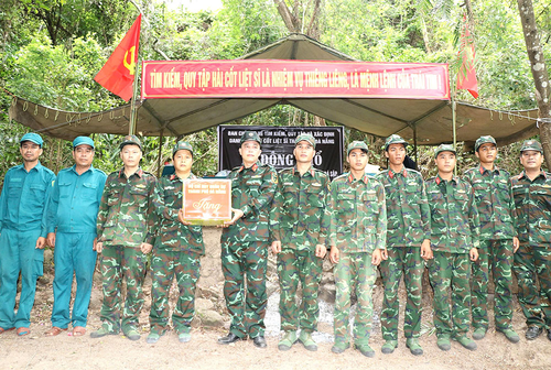 Đại tá Trần Hữu Ích, Chỉ huy trưởng Bộ CHQS TP Đà Nẵng trao quà tặng các lực lượng tìm kiếm hài cốt liệt sĩ tại hang Đá Sập (xã Hà Nha, TP Đà Nẵng). Ảnh: KHOA CHƯƠNG