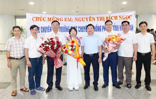 Ông Nguyễn Tiến Dũng (người đứng thứ tư từ phải qua) Giám đốc Sở GD&ĐT Ninh Bình cùng ban giám hiệu, thầy cô Trường THPT Chuyên Lê Hồng Phong đón và chúc mừng Nguyễn Thị Bích Ngọc trở về từ kì thi IPhO 2026 tại sân bay Nội Bài. Ảnh: Nhà trường cung cấp.