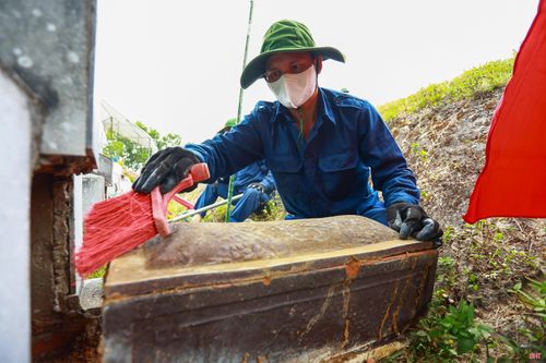 Từng tiểu quách chứa hài cốt liệt sĩ được cẩn trọng đưa ra khỏi phần mộ để phục vụ công tác lấy mẫu sinh phẩm.