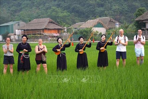 Du khách quốc tế trải nghiệm không gian văn hóa hát Then, đàn tính của đồng bào Tày tại thôn Tha, phường Hà Giang 1, tỉnh Tuyên Quang. Ảnh: Minh Tâm/TTXVN