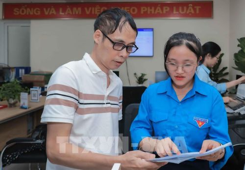 Đồng chí Phùng Thị Thúy Hằng, Phó Bí thư Đoàn Thanh niên Trung tâm Phục vụ hành chính công Hà Nội (Chi nhánh 06), luôn tận tình hỗ trợ người dân thực hiện thủ tục, giữ vững tinh thần "thân thiện, chuyên nghiệp" nhằm nâng cao chất lượng phục vụ công dân. Ảnh: Phan Phương - TTXVN