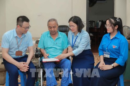 Tổ xung kích Trung tâm Phục vụ hành chính công Hà Nội đã đến tận nhà hỗ trợ làm thủ tục ủy quyền nhận lương hưu cho ông Nguyễn Văn Bưởi (69 tuổi, phường Phúc Lợi) do sức khỏe hạn chế, không thể đi lại. Ảnh: Phan Phương-TTXVN