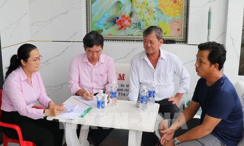 Bà Trần Thị Hoàng Quyên (trái), Giám đốc Phòng Giao dịch Ngân hàng Chính sách xã hội Châu Thành, trao đổi với hộ nhận nguồn vốn tín dụng. Ảnh: Hữu Chí - TTXVN