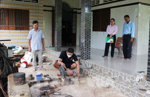 Cán bộ Ngân hàng CSXH cùng đại diện Hội Cựu chiến binh xã Long Hưng, tỉnh Đồng Tháp tham quan cơ sở hàn, tiện của anh Võ Thanh Tùng. Ảnh: Hữu Chí - TTXVN