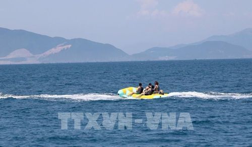 Du khách nước ngoài tận hưởng cảm giác mạnh với các môn thể thao dưới nước. Ảnh: TTXVN phát 