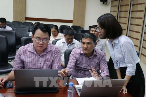 Đại diện Tập đoàn VNPT hướng dẫn đại biểu sử dụng phầm mềm quản lý sử dụng tạm thời lòng đường, hè phố. Ảnh: Tiến Lực - TTXVN