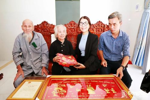 Phó Bí thư Thường trực Đảng ủy phường Xuân Lộc Ngô Thị An thăm hỏi, chúc mừng và trao tặng vải lụa cho cụ Hồng. Ảnh: Ngọc Hoàng