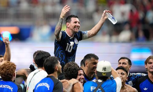 “Tay trong tay với Leo, chúng ta sẽ đạt được mọi thứ”, cổ động viên Argentina hát trong lúc các cầu thủ nâng Messi lên cao. (Ảnh: AP)