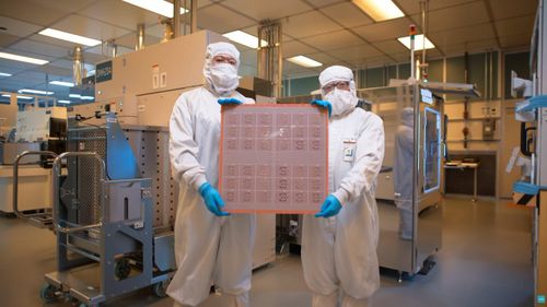 Các kỹ sư Intel giới thiệu một tấm wafer bán dẫn tại phòng sạch của nhà máy. Ảnh: Intel.