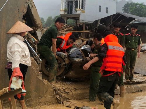 Lực lượng chức năng cùng người dân khắc phục hậu quả lũ quét tại xã Mường Than, tỉnh Lai Châu. Ảnh: Quý Trung - TTXVN