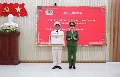 Thừa ủy quyền của Chủ tịch nước, Đại tá Võ Thị Trinh trao Huy chương Chiến sĩ vẻ vang cho Đại úy Phan Đình Chỉnh.