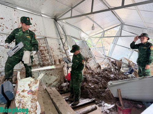Cán bộ, chiến sĩ Đồn Biên phòng Pa Ủ hỗ trợ nhân dân khắc phục hậu quả thiên tai. Ảnh: Biên Cương
