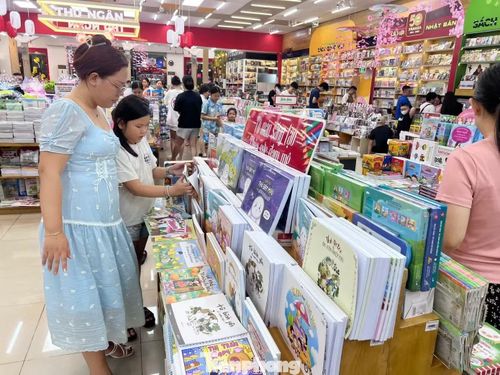 Phụ huynh tìm mua sách giáo khoa cho con trước thềm năm học mới. Ảnh: Uyên Phương