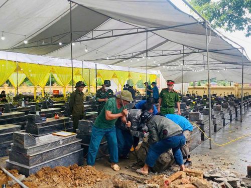 Lực lượng chức năng tiến hành lấy mẫu hài cốt liệt sĩ.